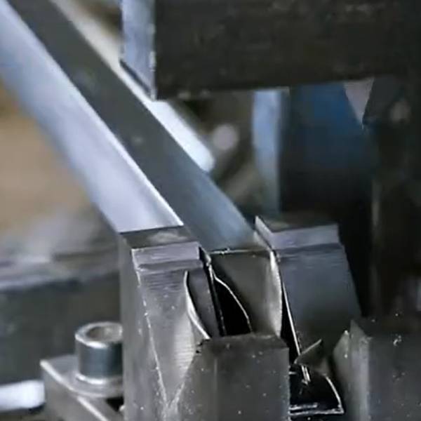 The inclined cutting machine is cutting the square tube into desired shapes.